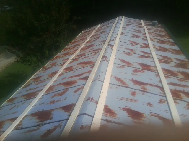 Rusted metal roof panels with new wood purlins before replacement — Storm Damage Roof Repair in Oklee by Roofing Brothers