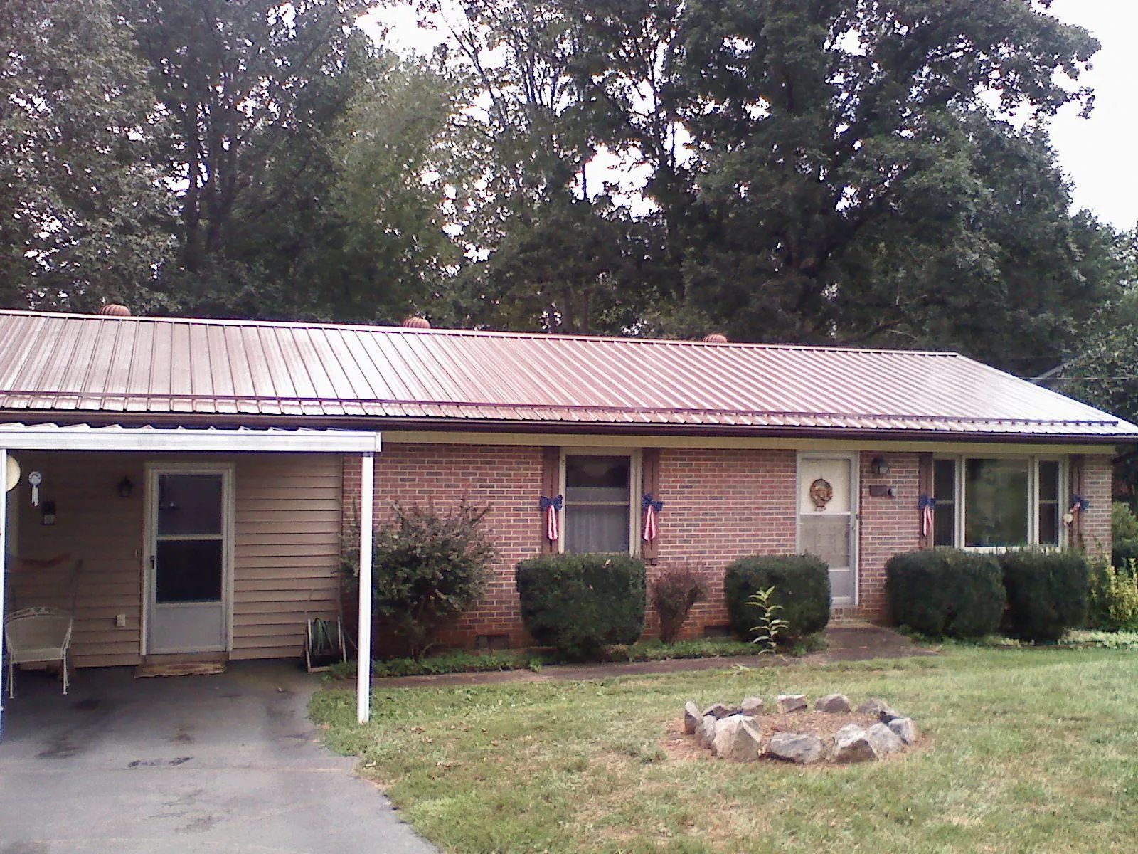 Bronze metal roof and carport on a brick ranch home — Roof Repair work by our crew in Oklee